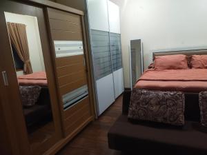 a bedroom with a bed and a sliding glass door at Traveler Guest House Yasmin Bogor Barat in Bogor