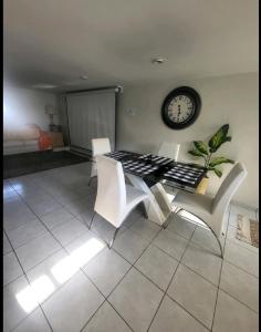 a room with a table and chairs and a clock at bassement whit jackuzzi and pool in Copiague