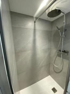 y baño con ducha con cabezal de ducha. en Appartement moderne, en Saint-Vallier