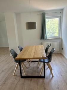 une table à manger avec quatre chaises et une fenêtre dans l'établissement FeWo Beim Museumsdorf, à Buchholz in der Nordheide