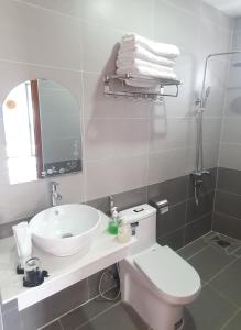 een badkamer met een wastafel, een toilet en een spiegel bij LUCKY HOTEL in Vung Tau