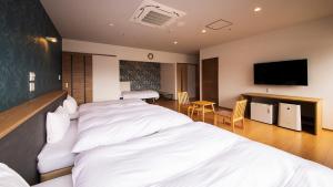 Habitación de hotel con 2 camas y TV de pantalla plana. en リゾートホテル美萩, en Hagi