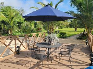 un tavolo e sedie con ombrellone blu su un patio di Bougainvilla a Abidjan