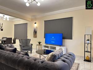 een woonkamer met banken en een flatscreen-tv bij After 5 Apartment 2 3 spacious en-suite bedrooms in Freetown