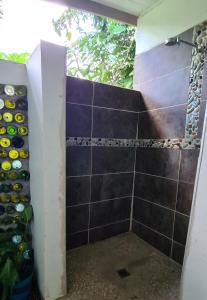 a bathroom with a shower with a bunch of bottles at Stay at Eden on the River in Port Vila