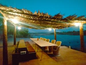 BānswāraにあるMahirosaのテーブルと椅子が備わるデッキから水辺の景色を望めます。