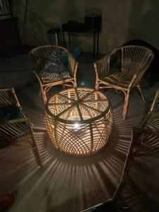 3 sedie di vimini e un tavolo in una stanza di Maison moderne au calme a Saint-Vallier