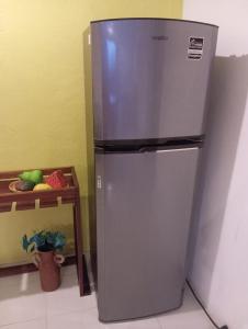 een roestvrijstalen koelkast in een keuken met een tafel bij HOSPEDAJE MAGNOLIAS MERIDA in Mérida