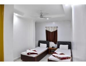 Jyoti Guest House, Bodh Gaya في بود جايا: غرفة بسريرين ونافذة