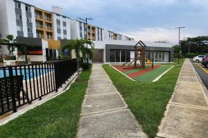 un parque infantil frente a un edificio de apartamentos con parque infantil en Moderno Apartamento muy cerca de Cali en Jamundí