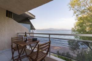 una mesa y sillas en un balcón con vistas al agua en Seaside Serenity Suite in Loutra, en Kato Almirí