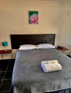 a bedroom with a large bed with two towels on it at Travellers Point Hotel in Apia