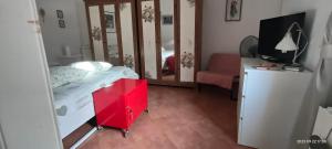 una camera con letto e comò rosso di Casa RoSiLù a Monopoli