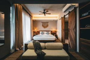 - une chambre avec un lit et un canapé dans l'établissement Isla Amara Resort, à El Nido