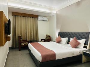 a hotel room with a bed and a chair at Nexstay Kassaba Inn in Kozhikode