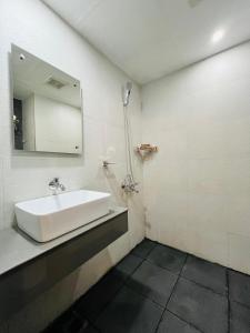 a white bathroom with a sink and a mirror at Nexstay Kassaba Inn in Kozhikode