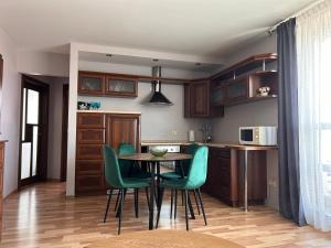 cocina con mesa y sillas verdes en una habitación en Baltijos 12b Apartamentai, en Klaipėda