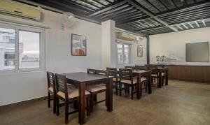 Treebo Trend The Rise في حيدر أباد: غرفة طعام بها طاولات وكراسي وتلفزيون بشاشة مسطحة