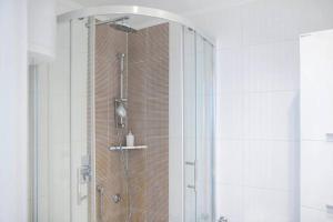 bagno con doccia e porta in vetro di Gajba Apartment a Belgrado