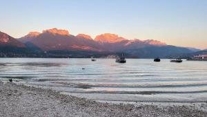 a body of water with boats in it with mountains at Le Chalet de la Plage in Sévrier