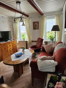 uma sala de estar com um sofá e uma mesa em Ferienhaus Katinka em Krummhörn