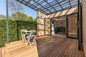 a wooden deck with a table and chairs on it at On The Hills in Hillcrest