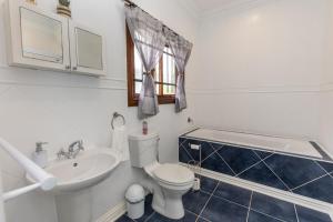 een badkamer met een wit toilet en een wastafel bij On The Hills in Hillcrest