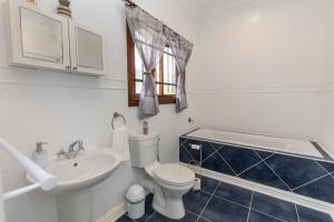 a bathroom with a white toilet and a sink at On The Hills in Hillcrest