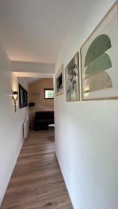 a hallway with paintings on the wall and a living room at Le Chalet de la Plage in Sévrier