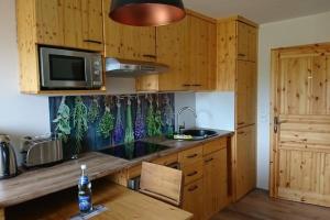a kitchen with wooden cabinets and a sink and a microwave at Ferienwohnung LeoFix in Klütz