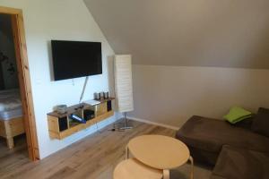 a living room with a couch and a table and a tv at Ferienwohnung LeoFix in Klütz