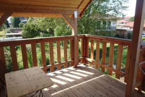 a wooden deck with a chair on a porch at Ferienwohnung LeoFix in Klütz +6 photos