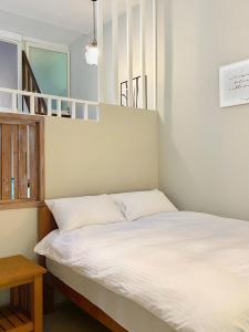 una camera da letto con un letto con lenzuola bianche di 寵物友善九份沐石原宿一館mu shi b&b a Ruifang