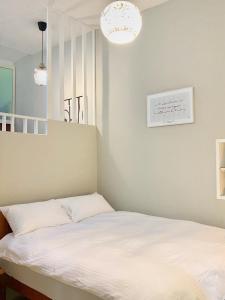 una camera da letto con un letto con lenzuola bianche di 寵物友善九份沐石原宿一館mu shi b&b a Ruifang