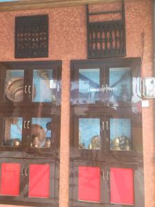 a set of glass doors with red squares on a wall at Ishani House in Bharatpur