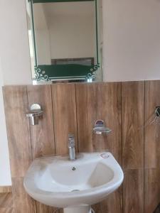 a bathroom with a white sink and a mirror at Ishani House in Bharatpur