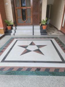 a star on a tile floor in front of a door at Ishani House in Bharatpur