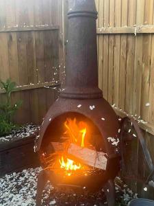 een bakstenen oven met een vuur in een tuin bij Glen Erin Hut in Gillingham