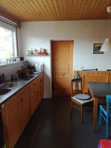 uma cozinha com armários de madeira, uma mesa e uma porta em Warthe - Mitten in der Natur em Warthe