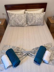 a bed with two blue and white towels on it at Maria Apartment in Gjirokastër