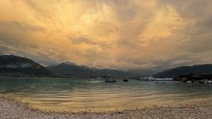 a cloudy sky over a body of water with mountains at Le Chalet de la Plage in Sévrier