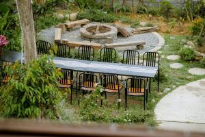 un jardín con un parque infantil con sillas y una hoguera en Hue Crown A Luoi Retreat, en Ha Tia
