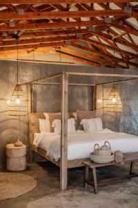 ein Schlafzimmer mit einem großen Bett mit einem Holzrahmen in der Unterkunft Minara Private Boutique Game Lodge in Dinokeng Game Reserve