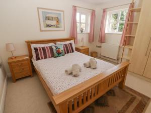 a bedroom with a wooden bed with towels on it at 3 Strawberry Close in Little Haven