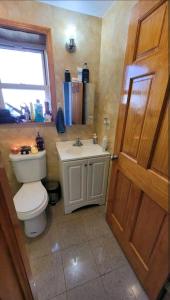 a bathroom with a toilet and a sink at Cozy large room in convenient location near Manhattan by train in Queens