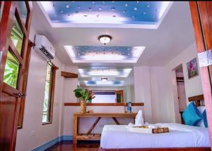 a bedroom with a bed and a table and a ceiling at Peak View Resort in San Vicente
