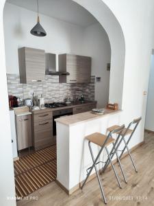 a kitchen with a counter and two chairs in it at Casa delle Muse 48 in Fontane Bianche