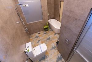 a bathroom with a toilet and a sink and a mirror at Tharusha Hotel in Galle