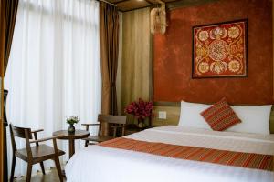 - une chambre avec un lit blanc et un mur rouge dans l'établissement Hue Crown A Luoi Retreat, à Ha Tia