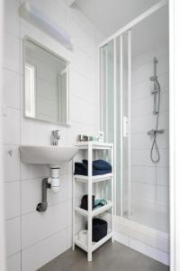 a white bathroom with a sink and a shower at Charmant studio, au cœur de la ville de Riom in Riom